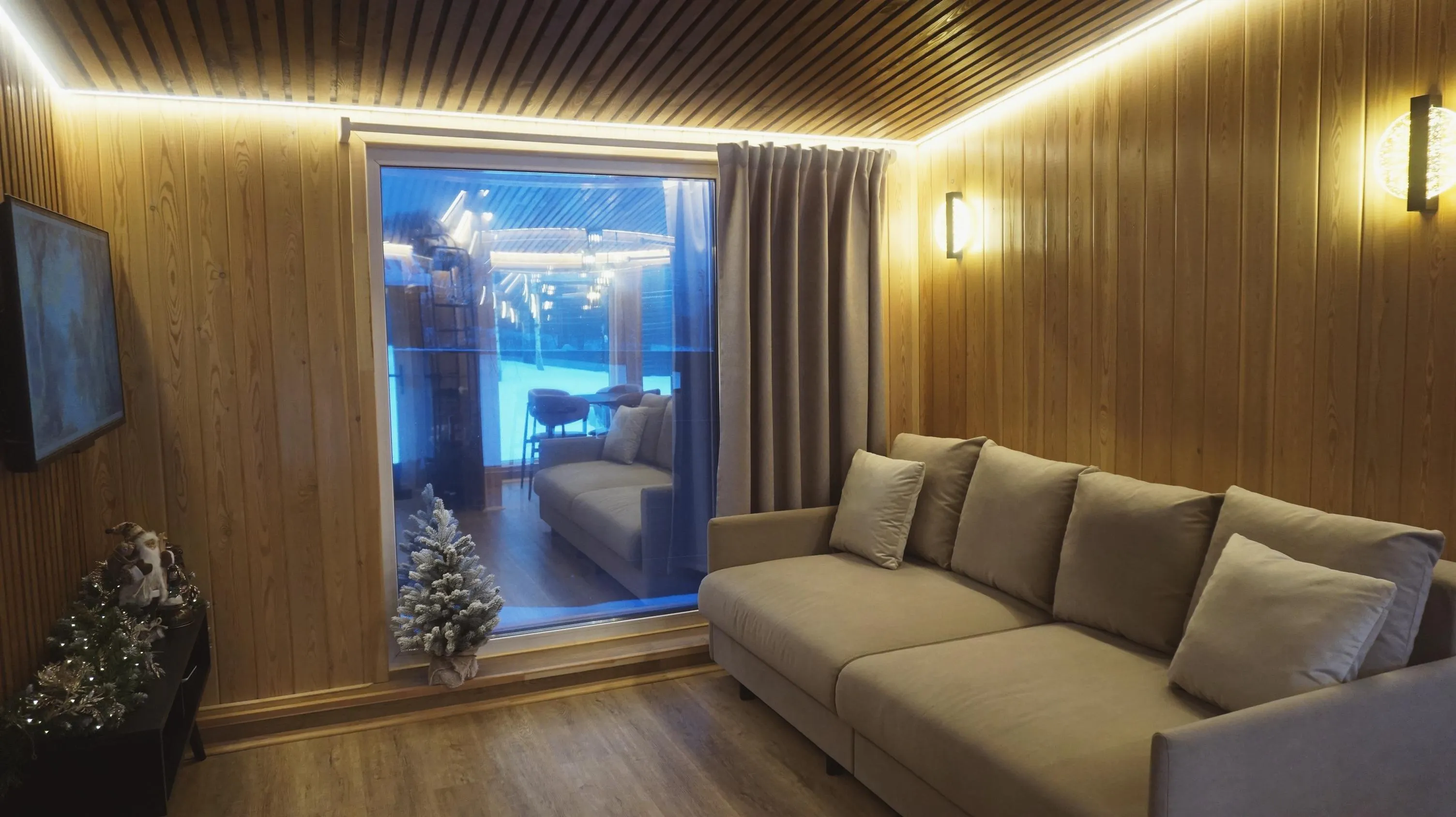 Панорамное окно и диван в гостиной дома